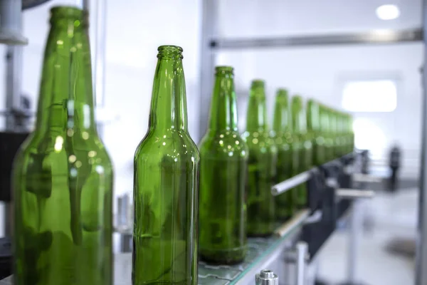 Beer production plant and glass bottles on conveyor machine.