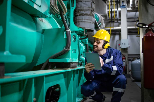 Power plant engineer controlling gas generator inside factory. Electricity production.