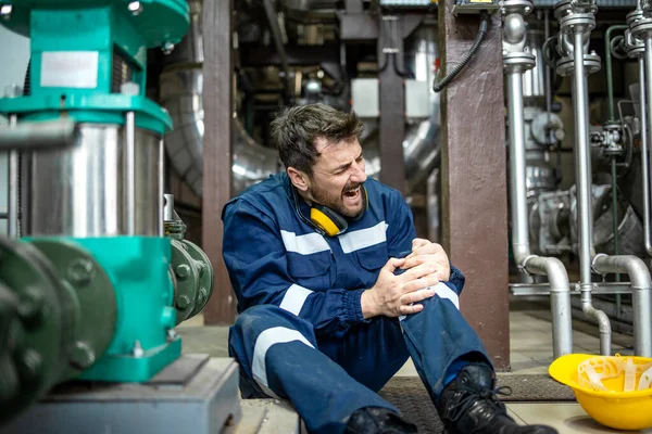 Refinery worker got himself injured during work sitting on the floor having knee pain.