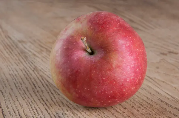 Красное яблоко на столе — стоковое фото