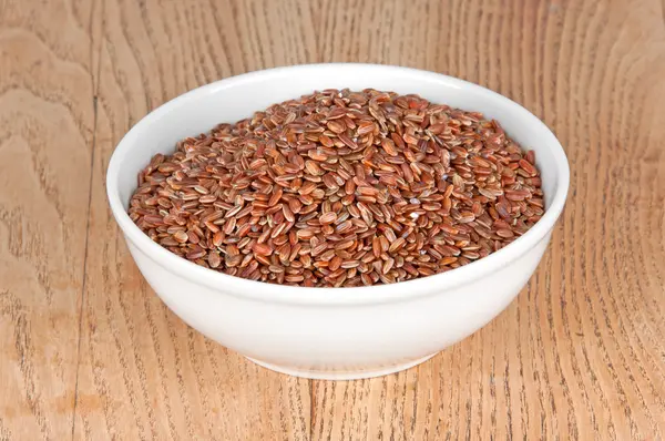 Red rice in a bowl on the table — Stock Photo, Image