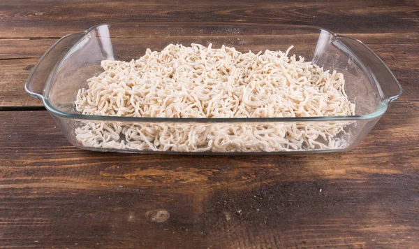 Egg noodles raw in a glass bowl — Stock Photo, Image