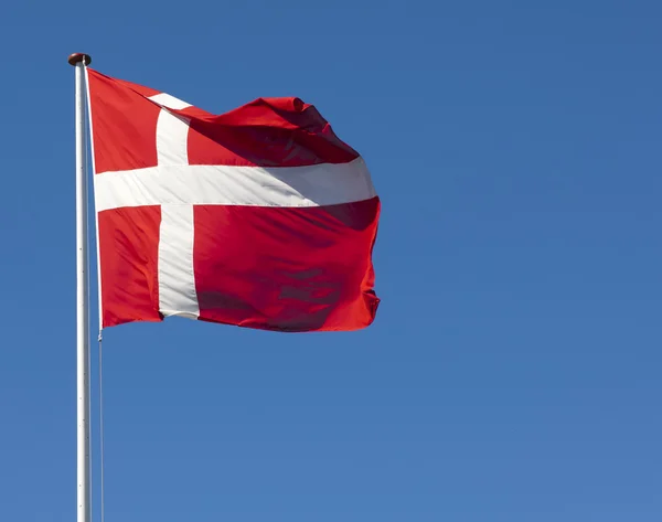 De Deense vlag, de dannebrog, tegen een blauwe hemel — Stockfoto