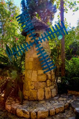 Julis, İsrail - 22 Ekim 2021: El Mona bahçeleri içinde değirmen, aşkın güzel bir kanıtı. Julis 'in Druze köyünde. Çiçekler, ağaçlar, çalılar ve Dürzi kültürünün sembolleri var..