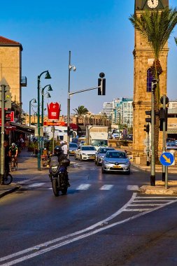 Tel-aviv, İsrail - 11 Kasım 2021: Jaffa Saat Kulesi yakınlarındaki meydanda araba ve insan trafiği yoğun. Osmanlı Sultanı 2. Abdul Hamid 'in 25. yıldönümünü kutlamak için 1906' da kireçtaşı bloklardan inşa edildi..