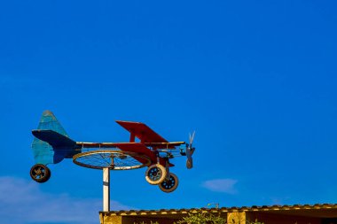 Güneşli bir günde mavi gökyüzüne karşı bisiklet tekerleğinden ev yapımı rüzgar gülü uçak ve renkli tahtalar. arkaplan
