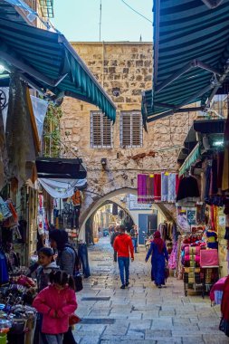 Kudüs, İsrail - 23 Kasım 2021: alışveriş merkezlerinin yakınındaki insanlar, küçük hediyelik eşya dükkanları. Eski Kudüs şehrinin sokaklarından birinde turist malları satışı