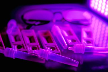 5 covid-19 antijen testleri, tampon şişeler ve koyu kırmızı arka planda ince siyah çerçeveli gözlükler. Kendi kendini test. Evde test edin. Corona, Coronavirus SARS-CoV-2 grip salgını