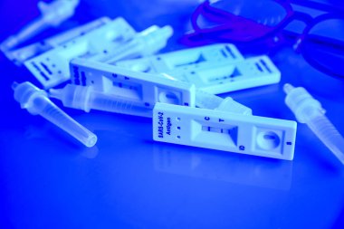 6 covid-19 antijen testi pozitif, tampon şişeler ve ince siyah çerçeveli gözlük mavi tonlarda. Kendi kendini test. Evde test edin. Corona, Coronavirus SARS-CoV-2 grip salgını