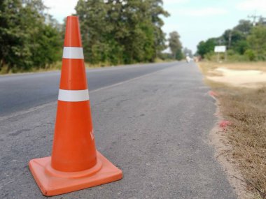 Kırmızı lastik koniler asfalt yola konur. Yoldaki güvenlik için
