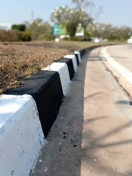 黒と白の塗装作業コンクリートバリア縁縁部と側溝 — ストック写真