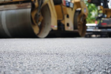 Asfaltlı yolların yapımında görüntü bulanıklaşıyor. Ağır makinelerle.
