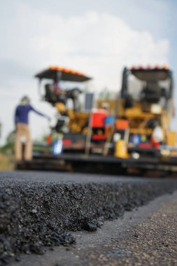 Asfaltlı yolların yapımında görüntü bulanıklaşıyor. Ağır makinelerle.