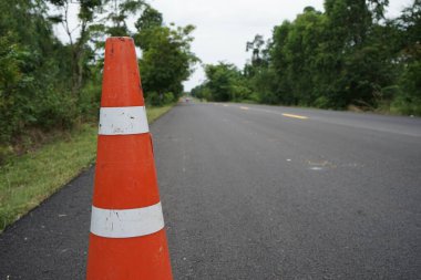 Kırmızı lastik koniler asfalt yola konur. Yoldaki güvenlik için