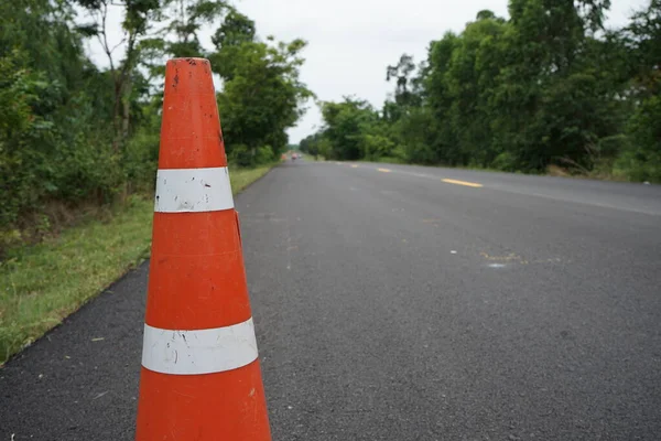 Kırmızı lastik koniler asfalt yola konur. Yoldaki güvenlik için