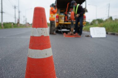 Kırmızı lastik koni ve bulanık arkaplan görüntüsü yolda çalışıyor.