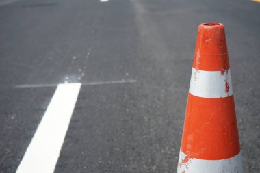 Kırmızı lastik koniler asfalt yola konur. Yoldaki güvenlik için