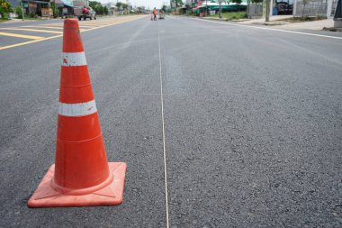 Kırmızı lastik koniler asfalt yola konur. Yoldaki güvenlik için