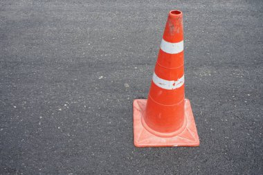Kırmızı lastik koniler asfalt yola konur. Yoldaki güvenlik için