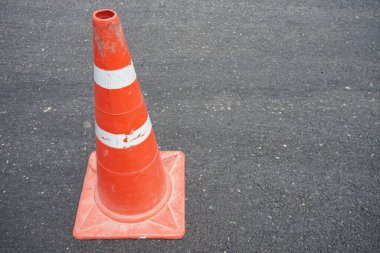 Kırmızı lastik koniler asfalt yola konur. Yoldaki güvenlik için