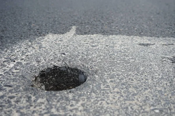 Holes from drilling to measure asphalt road thickness