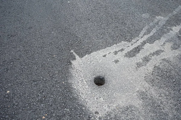 Holes from drilling to measure asphalt road thickness