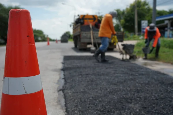 Blurred image of pavement repair work. It's a low angle photo.