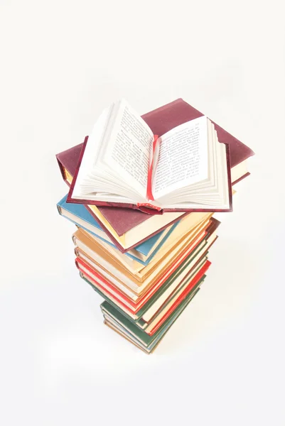 Högen av böcker med en bok öppen — Stockfoto