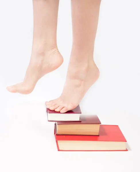 Person standing on a stack of books — Stock Photo, Image