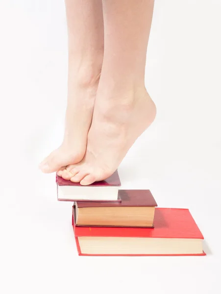 Person som står på en trave böcker — Stockfoto