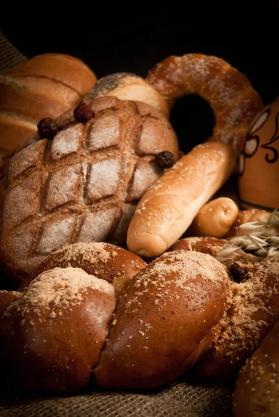 Assortment of baked bread on sacking — Stock Photo, Image