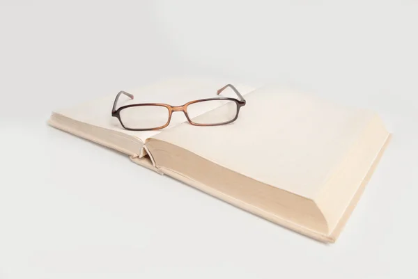 Libro con gafas aisladas en blanco — Foto de Stock