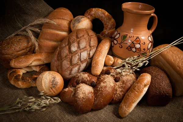 Assortment of baked bread on sacking — Stock Photo, Image