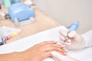 Havluyla pembe manikürlü güzel bir salon prosedürü. Tırnak cilası.