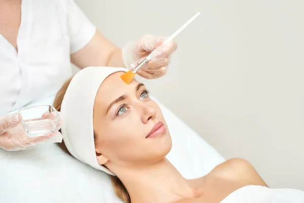 Procedimiento de belleza de cosmetología. Cuidado de la piel de mujer joven. Hermosa persona femenina — Foto de Stock