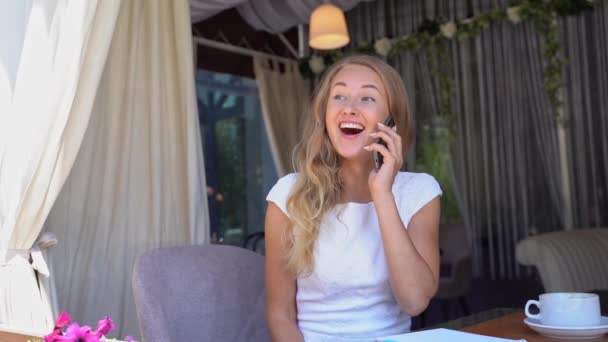 Una mujer joven y bonita hablando por teléfono. Feliz persona femenina al aire libre — Vídeo de stock