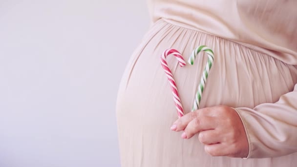 Pregnant skin care. Morning body routine. Woman belly with candy cane — Stock Video