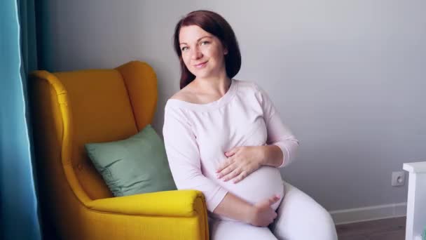 Zwangere huidverzorging. Ochtend lichaamsroutine. Vrouw buik. Vrouwelijke persoon zittend — Stockvideo