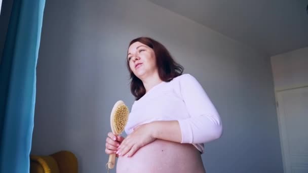Zwangere huidverzorging. Bodyborstel routine. Een vrouw die buikschilfert. Vrouwelijke persoon — Stockvideo