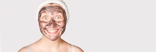 Jovem mulher aplicando máscara preta. Carvão vegetal produto facial. Acne e espinha — Fotografia de Stock