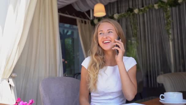 Μια όμορφη νεαρή γυναίκα μιλάει στο τηλέφωνο. Ευτυχής γυναίκα σε εξωτερικούς χώρους — Αρχείο Βίντεο