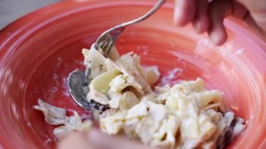 Man eating carbonara pasta. Cooking fettuccine sauce. Spoon and fork dinner