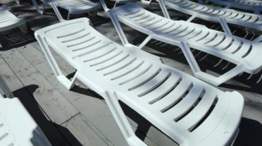 Yüzme havuzunun yanındaki boş iskemle. Plastik plaj sandalyesi.