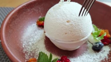 Çatallı insanlar Pavlova tatlısını kırar. Masada beyaz kremalı tatlı yemek