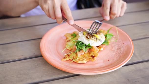 Man eating benedict egg. Cooking potato pancakes. Fork dinner — Vídeo de stock