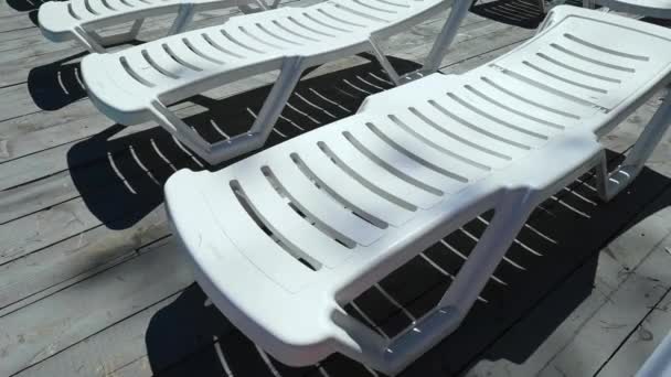 Cadeira de praia vazia perto da piscina. Cadeira de praia de plástico. — Vídeo de Stock