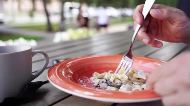 Man eating carbonara pasta. Cooking fettuccine sauce. Spoon and fork dinner — 图库视频影像