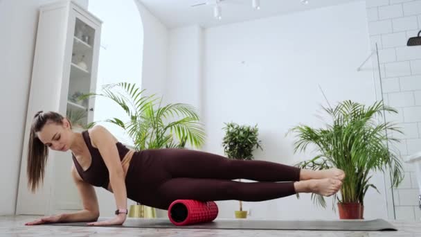 Mujer joven estirar el cuerpo en la alfombra de fitness. Masaje de liberación miofascial. Relájate. — Vídeo de stock
