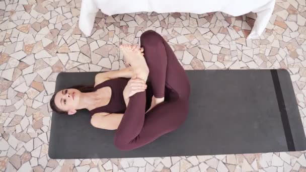 O tânără care face exerciții de yoga acasă. Lecții online de asistență medicală. Interior — Videoclip de stoc