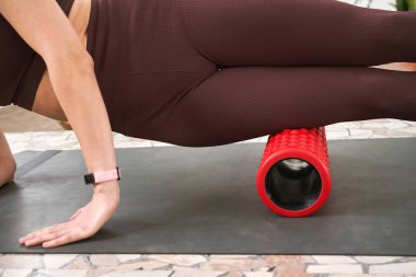 Genç bir kadın spor paspasına uzanıyor. Myofascial masajı